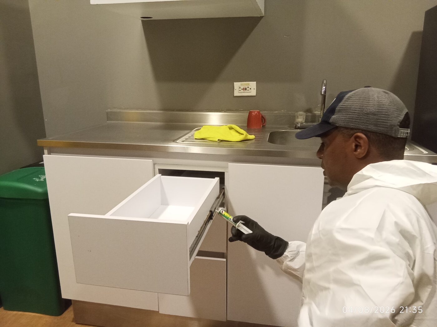 Aplicación de gel contra cucarachas en mobiliario de cocina en Cali